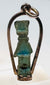 Side view of an Egyptian faience amulet showing its original suspension perforation