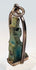Close-up of a blue-green faience deity amulet with age-related surface wear