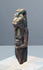 Ancient Egyptian protective amulet with one arm bent inward across the abdomen