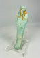 Slight left view of turquoise-blue Egyptian ushabti showing detailed mummiform body and carved inscriptions.
