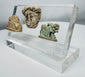 Faience Hathor amulet accompanied by carved stone lion and classical portrait fragment from antiquity.