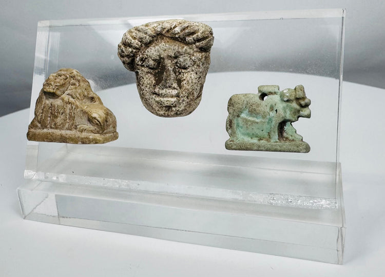 Collection of three archaeological artifacts from the ancient Mediterranean world presented in a modern acrylic display.