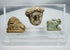 Ancient Egyptian and Greco-Roman antiquities mounted in a clear display case featuring religious and figural carvings.