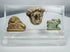 Ancient Mediterranean study collection featuring Egyptian devotional amulet and two carved stone figures.