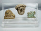 Ancient Mediterranean study collection featuring Egyptian devotional amulet and two carved stone figures.