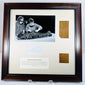 Dark wood frame displaying two attributed Manchester Mummy 1770 linen fragments beside a photograph of the 1975 investigation.