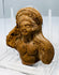 Ptolemaic Egyptian clay figurine fragment with female facial features and Hellenistic-influenced hairstyle.