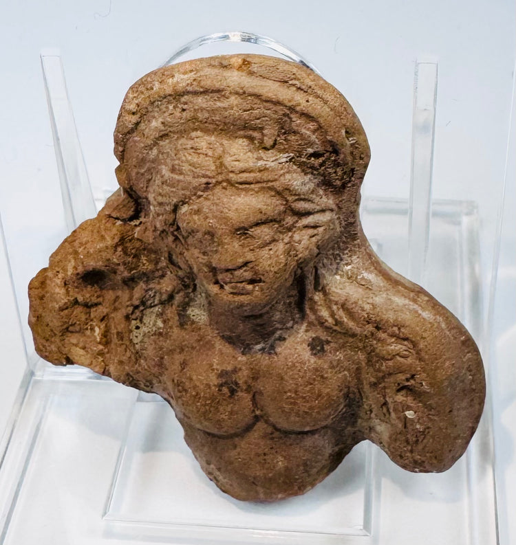 Ancient terracotta female figure fragment from Ptolemaic Egypt showing weathered facial details and aged surface patina.