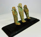 Three ancient Egyptian faience ushabti figures viewed from a diagonal angle on a black wooden display base.