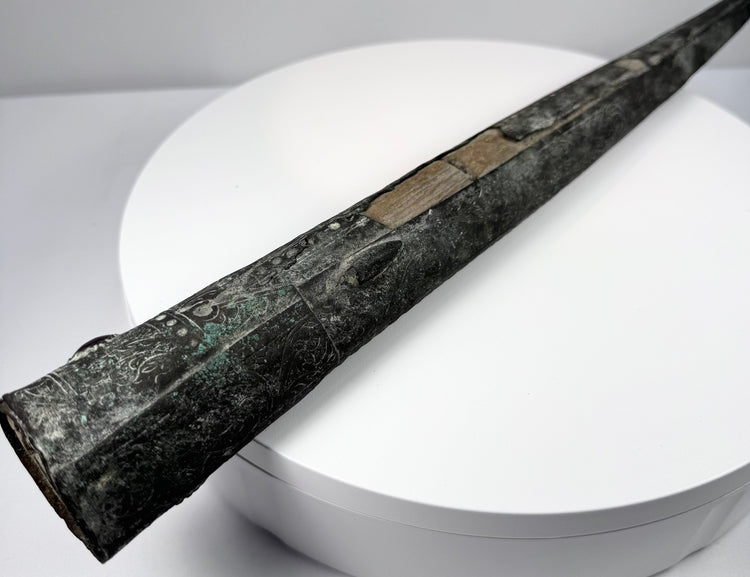 Wooden scabbard liner with two irregular openings separated by a central section of wood.