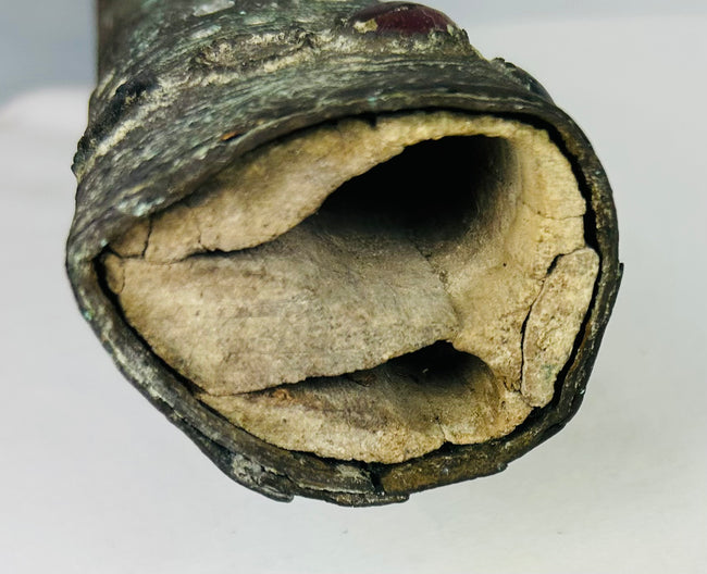 Detail of the pointed end of an Etruscan bronze sword sheath with deep green patina and ancient surface wear – authentic early Etruscan artifact