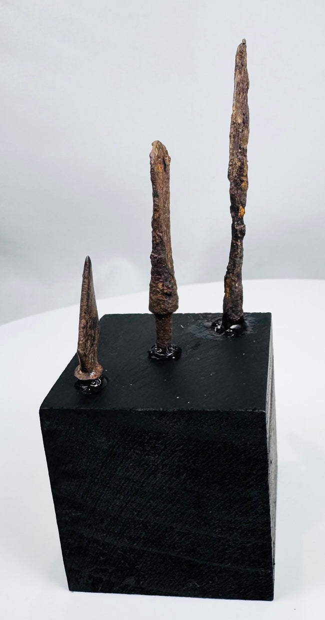 Roman and medieval iron arrowhead display showing archaeological patina and encrustation