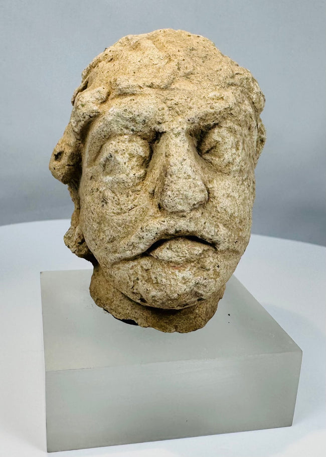 Weathered limestone head from ancient Gandhara representing a Bodhisattva figure from the Kushan to Post-Kushan period.