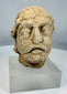 Weathered limestone head from ancient Gandhara representing a Bodhisattva figure from the Kushan to Post-Kushan period.