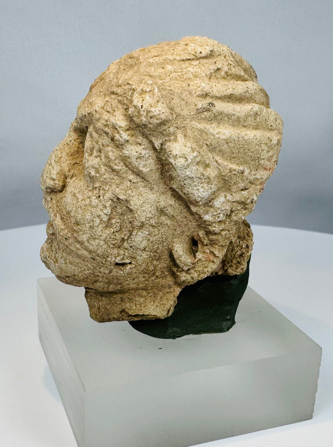 Ancient limestone head of a Bodhisattva Maitreya from Gandhara, reflecting Greco-Buddhist artistic traditions along the Silk Road.
