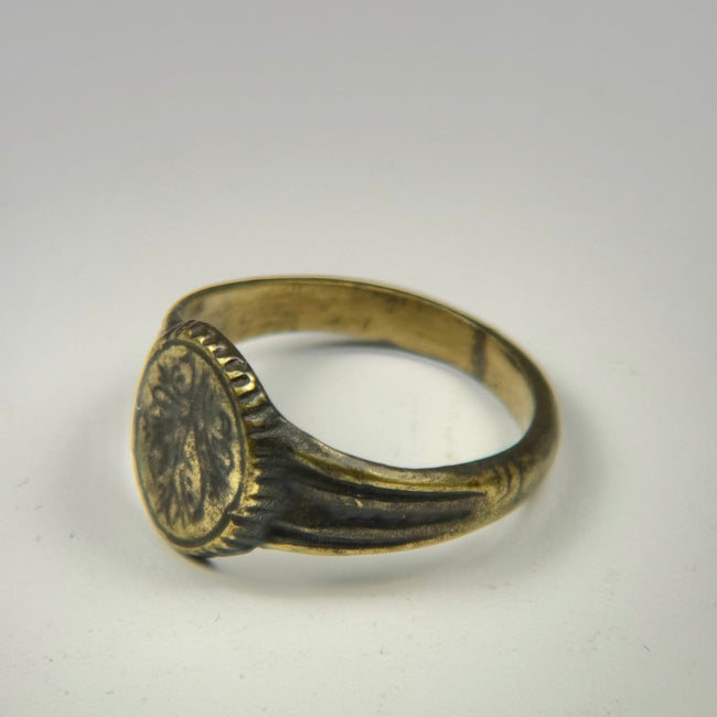 Ancient Eastern Mediterranean signet ring featuring an engraved floral motif and natural patina