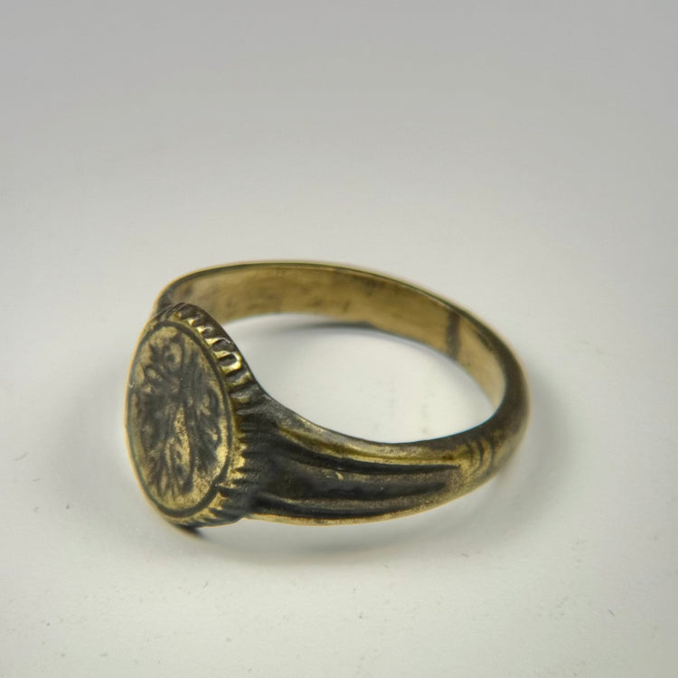 Ancient Eastern Mediterranean signet ring featuring an engraved floral motif and natural patina