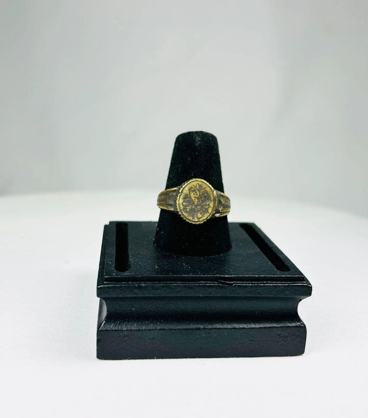 Ancient Mediterranean bronze ring with gold-gilded floral decoration, symbolic of renewal and prosperity