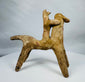 Ancient Greek horse and rider terracotta figure featuring stylized geometric forms and archaeological patina.