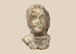 Ancient Greek terracotta protome with stylized human face, broad shoulders, and weathered pale surface