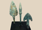 Three ancient Western Asiatic bronze projectile points mounted on a black display base