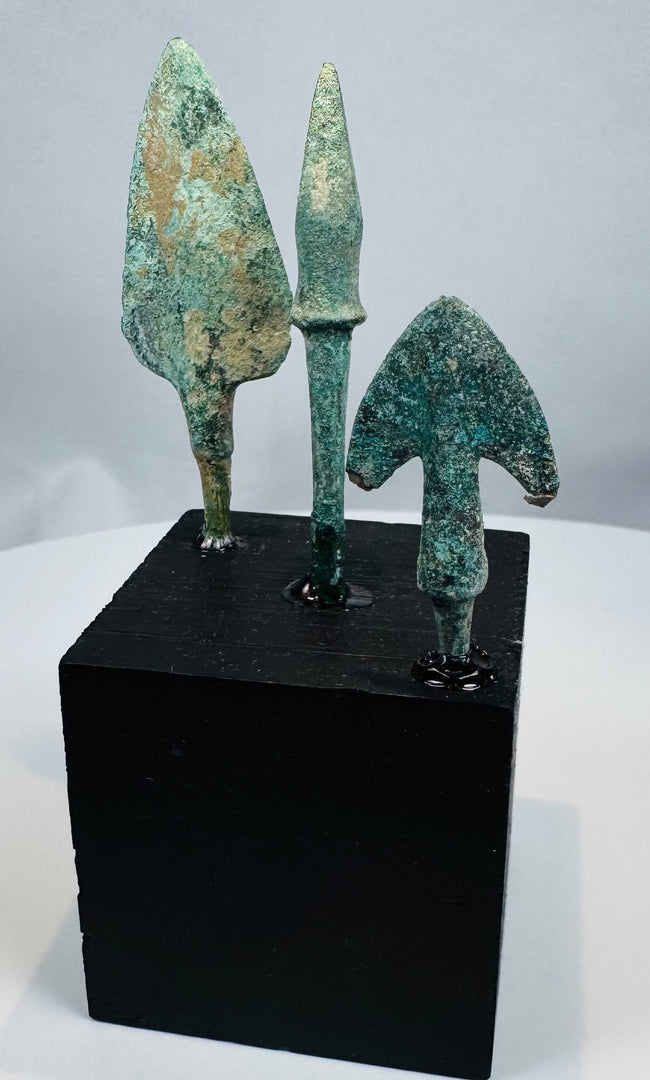 Broad leaf-shaped bronze projectile point with flat tang and green archaeological patina