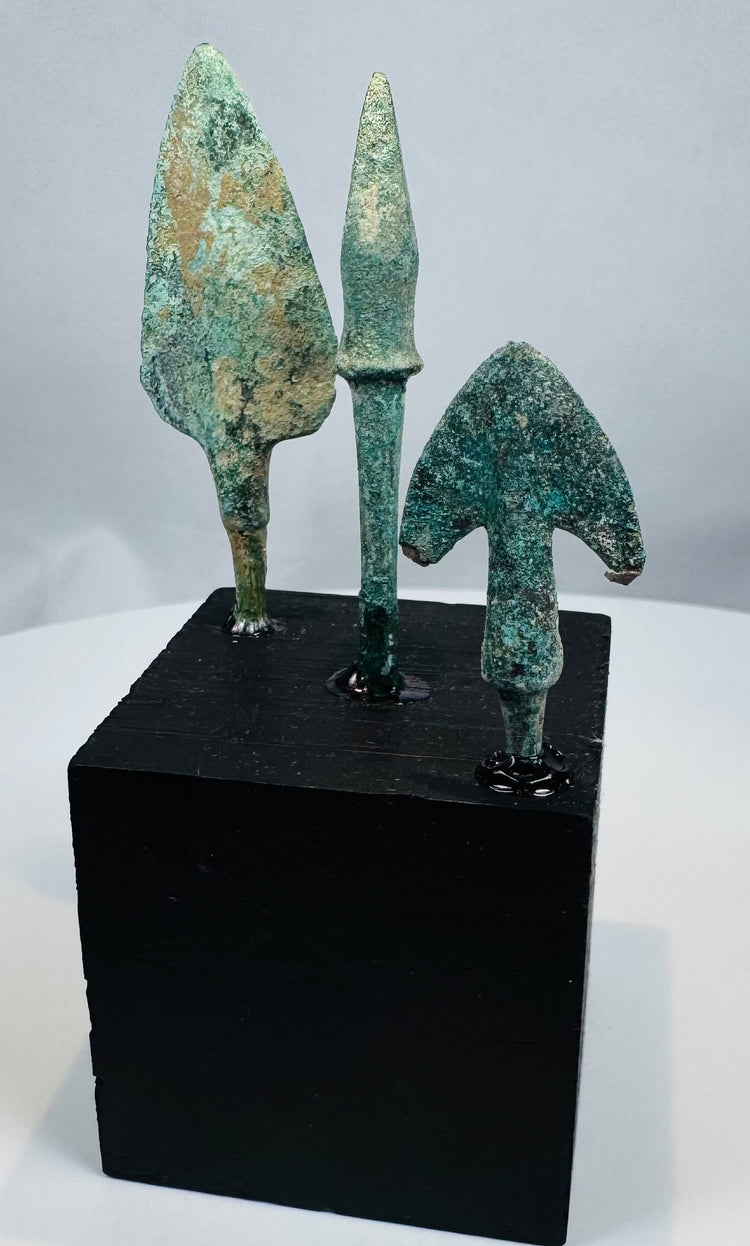 Broad leaf-shaped bronze projectile point with flat tang and green archaeological patina