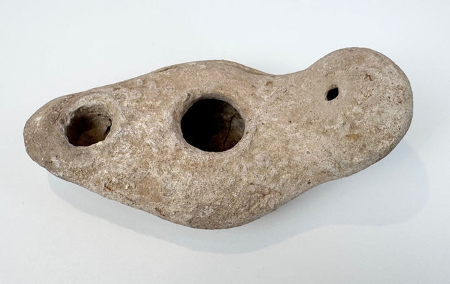 Ancient hand-formed oil lamp made from pale buff terracotta
