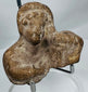 Close-up of an ancient Mediterranean terracotta bust highlighting archaeological weathering and mineral deposits.