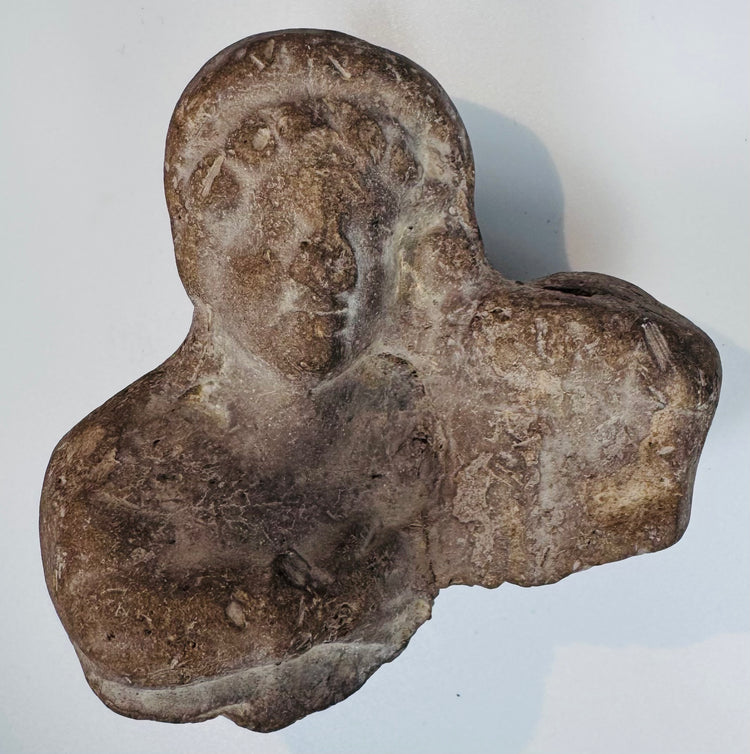 Authentic terracotta bust fragment with stylized facial features from the Classical Mediterranean world.