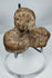 Ancient mold-made terracotta figurine fragment depicting a human bust with a headdress or hood.