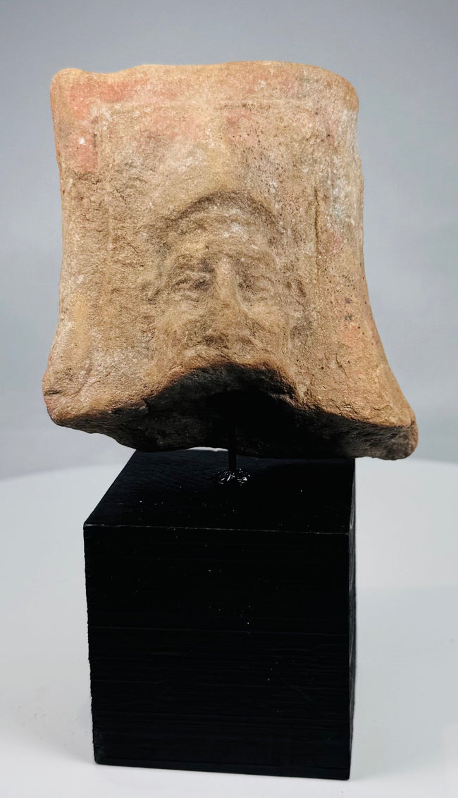 Ancient Mediterranean terracotta face with raised rectangular framing border