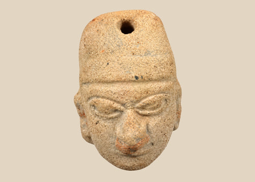 Terracotta pendant head with angular headdress, incised almond-shaped eyes, furrowed brow, and pronounced nose and lips; drilled suspension hole through top; mounted on a museum-style stand; West Mexico (Colima/Nayarit) or Veracruz, circa 300 BCE–300 CE.