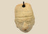 Terracotta pendant head with angular headdress, incised almond-shaped eyes, furrowed brow, and pronounced nose and lips; drilled suspension hole through top; mounted on a museum-style stand; West Mexico (Colima/Nayarit) or Veracruz, circa 300 BCE–300 CE.