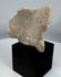 Weathered Mesoamerican terracotta face fragment with serene expression and surviving headdress details.