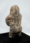 Mesoamerican carved stone human figure with compact proportions and abstract features