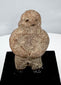 Stylized Pre-Columbian stone figure with rounded torso, short legs, and folded arms