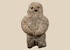 Pre-Columbian carved stone standing figure with folded arms and deeply recessed eyes