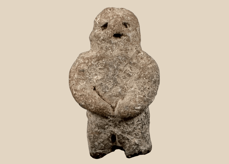 Pre-Columbian carved stone standing figure with folded arms and deeply recessed eyes