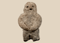 Pre-Columbian carved stone standing figure with folded arms and deeply recessed eyes