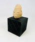 Front view of a West Mexican terracotta head fragment on display stand