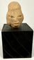 Frontal view of Ancient Mesoamerican terracotta head sculpture with elongated cranium and stylized features