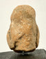 Rear view of ancient terracotta fragment with sandy texture and visible repair patch on upper back