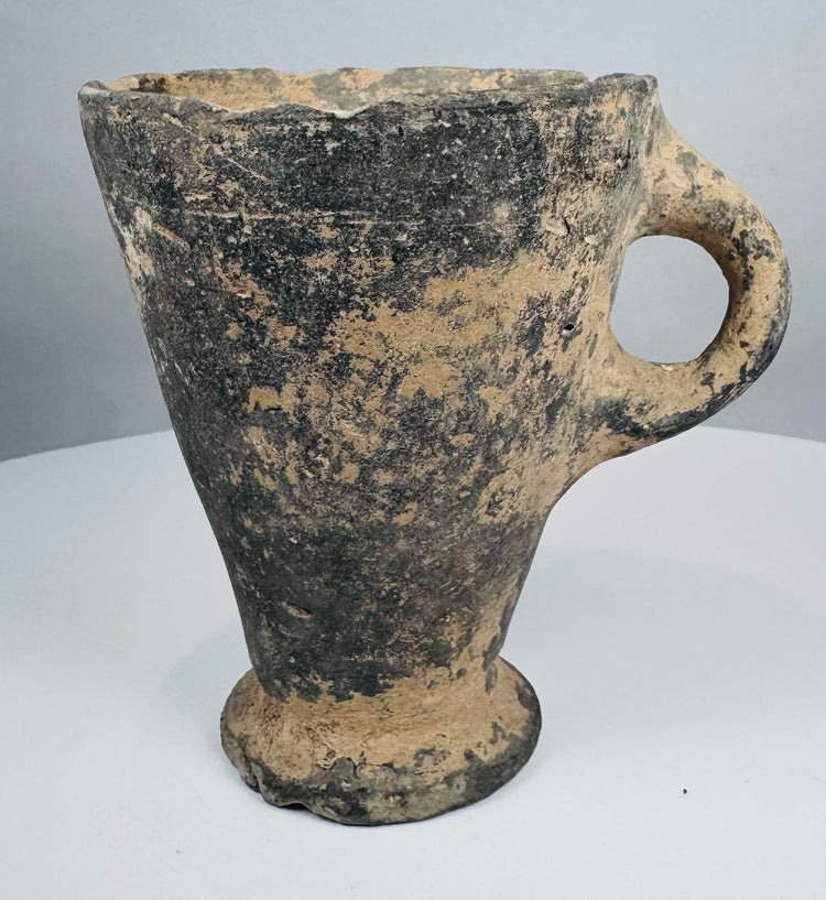 Ancient grayware drinking vessel with raised circular pedestal base
