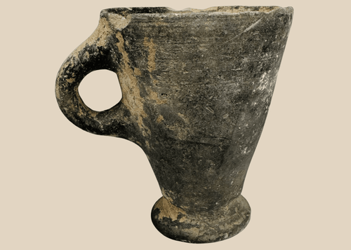 Ancient Near Eastern grayware pottery cup with flaring bowl and loop handle