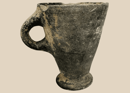 Ancient Near Eastern grayware pottery cup with flaring bowl and loop handle