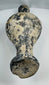 Close-up of dark burnished pottery surface with pale mineral accretions