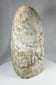 Ancient anthropomorphic stone carving with stylized proportions and aged texture
