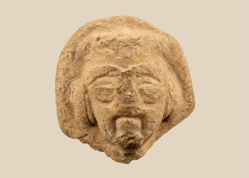 Fragmentary terracotta head with stylized arched brows, almond-shaped eyes, defined beard and mustache, and detailed coiffure; likely part of a votive or ritual figure from the Near East/Eastern Mediterranean, circa 1st millennium BCE; mounted on a custom black display base.
