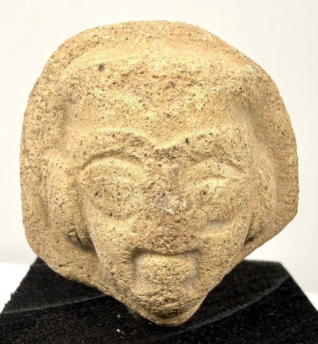 Close-up of beige clay sculpture showing prominent brow ridge and mouth details